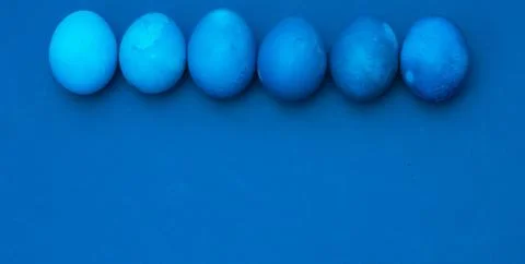 Classic blue easter eggs on blue background. monochromatic composition. place Stock Photos