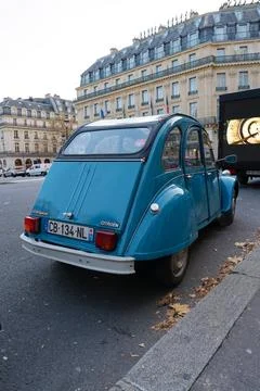 Classic blue vintage car parked on a city street in Paris during the early .. Stock Photos