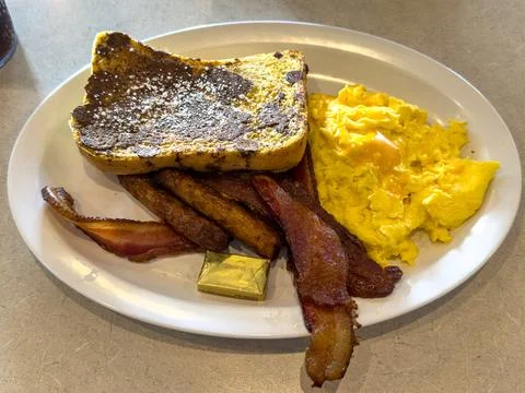 Classic Breakfast Plate With Scrambled Eggs Bacon and French Toast Stock Photos