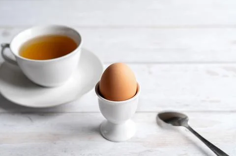 Classic breakfast with soft boiled egg and tea with copy space. Stock Photos