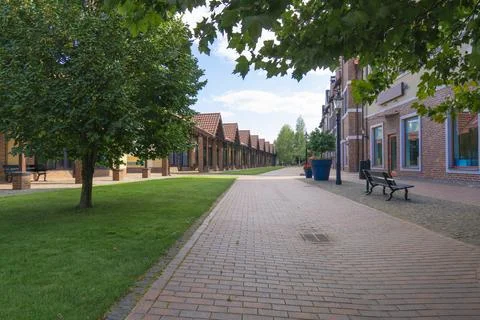 Classic brick buildings along paved alley in european town Stock Photos