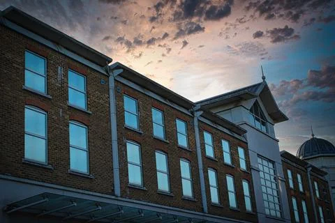 Classic building facade against a dramatic sunset sky with clouds. Fotos de archivo