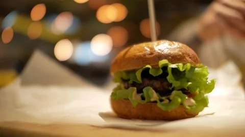 Classic burger on a table on parchment paper. fast food cafe Stock Footage 99822853
