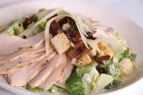 CLASSIC CAESAR SALAD closeup with cabbage, chicken slice, olive, bread and .. Stock Photos