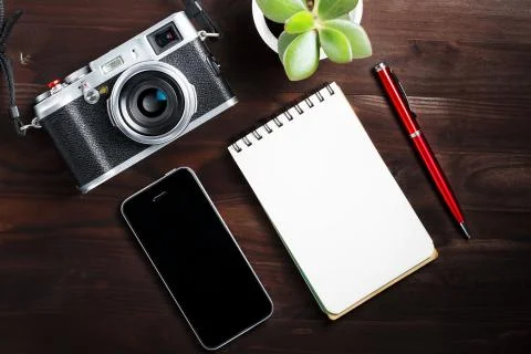 Classic camera with blank notepad page and red pen on dark brown wooden table 스톡 사진