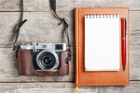 Classic camera with blank notepad page and red pen on gray wooden, vintage de 写真素材