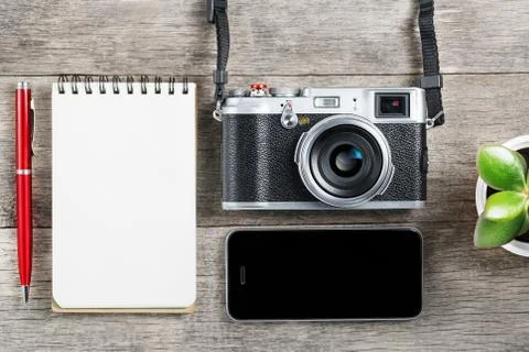 Classic camera with blank notepad page and red pen on gray wooden, vintage de Foto stock