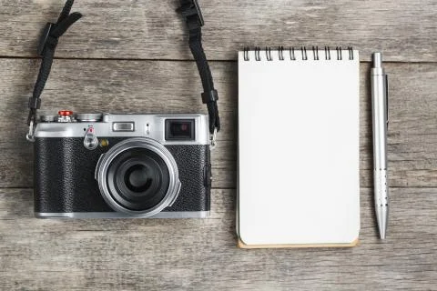 Classic camera with blank notepad page and gray pen on gray wooden, vintage d Foto stock