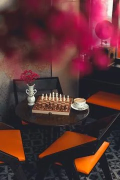 Classic chess game set beside coffee in a cafe Фото