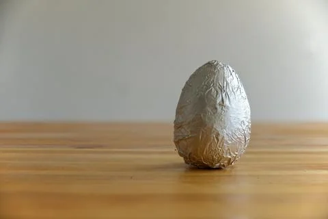 A classic chocolate egg resting on the table Stock Photos