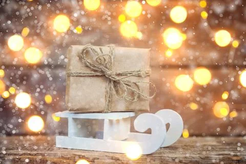 Classic Christmas composition winter objects sled with gift box on wooden bac Stock Photos