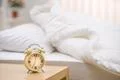 The classic clock on the background of the bed Photo