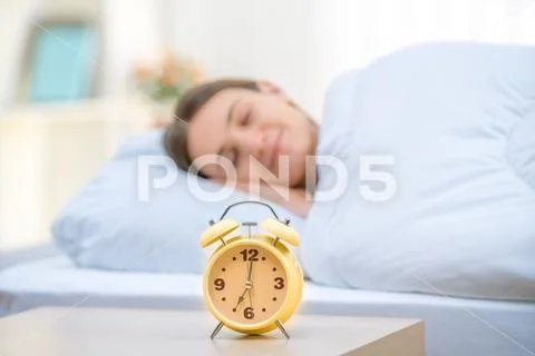 The classic clock on the background of a sleeping woman Stock Photos