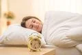 The classic clock on the background of a sleeping woman Photo