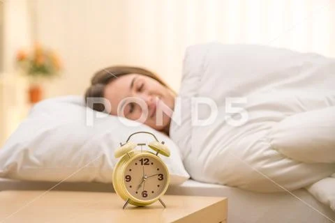 The classic clock on the background of a sleeping woman Stock Photos