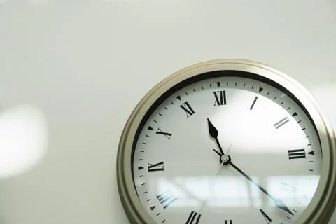 Classic clock on a white wall in the house. Close-up. Space for text Stock Photos