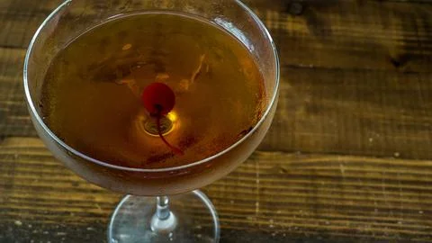 Classic Cocktail with Cherry Garnish on Rustic Wooden Surface Stock Photos
