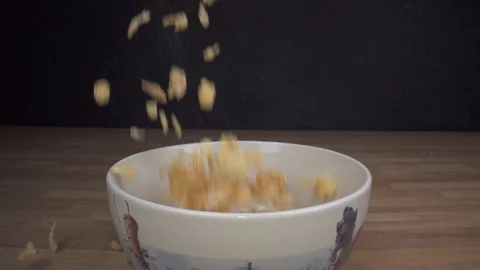 Classic Cornflakes falling into cup in slowmotion from above wide sliding shot Stock Footage 124015467