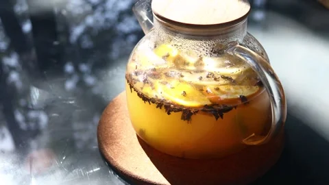 A classic glass pitcher filled with lemonade sits on a wooden tabletop, rea.. Stock Footage 342430995