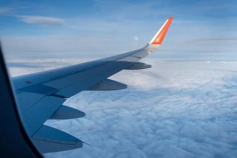 Classic image through aircraft window onto wing. Flight view over clouds Stock Photos