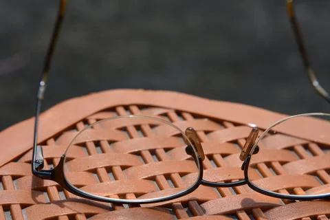 Classic metal frame Spectacles lying down on plastic stool Stock Photos
