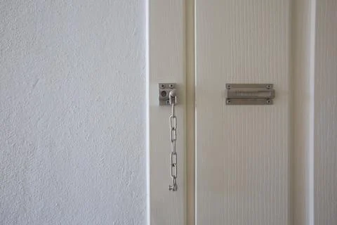 Classic Metal Security Chain Bolt Lock on a White Wooden Door Stock Photos