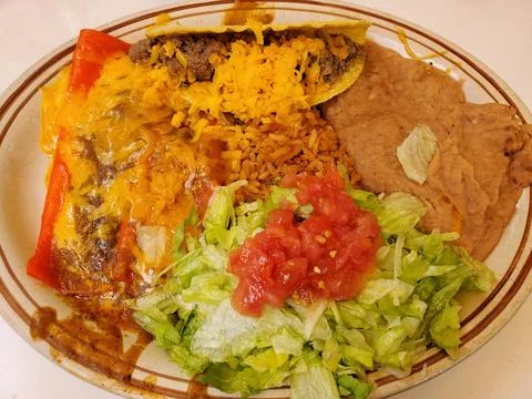 A classic Mexican-style platter, featuring a ground beef hard taco, a chees.. Foto stock