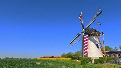 Classic Netherlands windmill surrounded by open landscape under a sunny blu.. Stock Footage 340228918