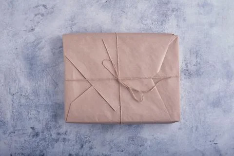 A classic parcel wrapped in kraft paper and tied with natural jute twine ag.. 스톡 사진