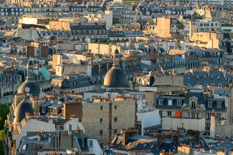 Classic Paris rooftops with domes in evening light 스톡 사진
