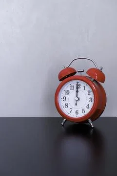 The classic red alarm clock on a table Stock Photos
