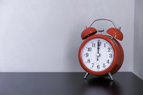 The classic red alarm clock on a table Stock Photos