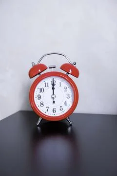 The classic red alarm clock on a table Stock Photos