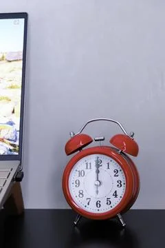 The classic red alarm clock on a table Stock Photos