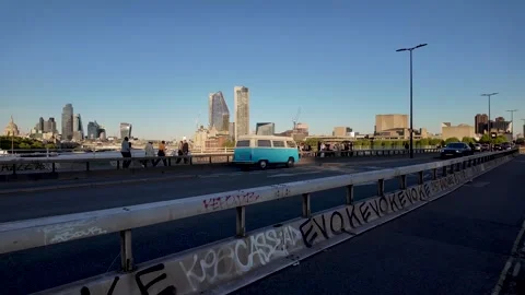 A classic red double decker bus drives along Waterloo Bridge Road in London. Видео 334293879