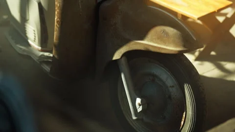 Classic retro rusty scooter parked under a metal sheet awning shade. Stock Footage 330969488