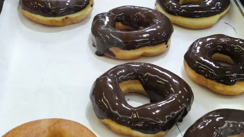Classic ring donuts coated with a thick and glossy chocolate glaze Stock Footage 339286089