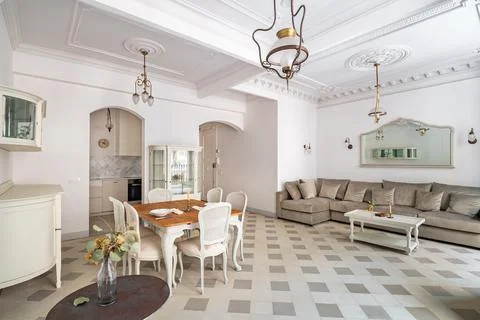 Classic room with dining table, served for two persons, sofa, tile floor, lig 스톡 사진
