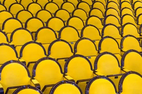 Classic rows of empty yellow seats in a cinema or theatre. Hall without visitors Stock Photos