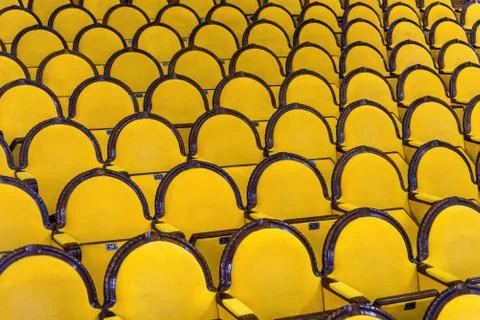 Classic rows of empty yellow seats in a cinema or theatre. Hall without visitors Stock Photos
