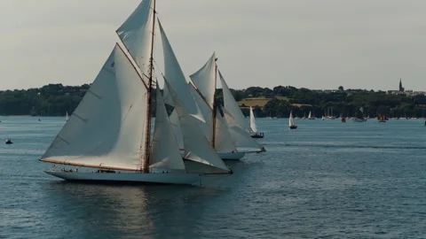 Classic sailing yachts racing side by side under full sail in a coastal regatta. Stock-Footage 345287547