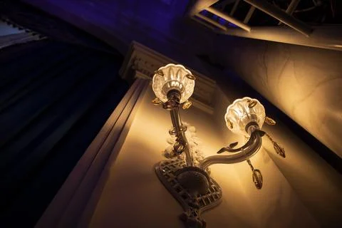 Classic sconce glows in a dark classic interior, bottom view Stock Photos