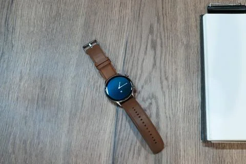 Classic smart watch on a rustic table with space for text on white notebook Foto stock