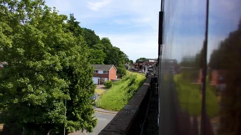 Classic steam train approaching countryside station platform bridge Stock Footage 80311869