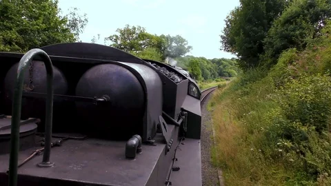 Classic steam train producing smoke travelling through countryside Stock Footage 80287613