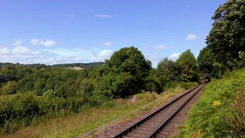 Classic steam train producing smoke travelling through countryside Stock Footage 80323812