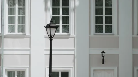 Classic street lamp post in front of white building with large windows. Vídeos de archivo 300483488