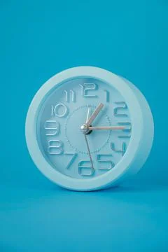 Classic table clock isolated on blue background, vertical image Illustration