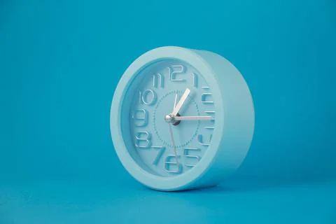 Classic table clock isolated on blue background, horizontal image Illustration