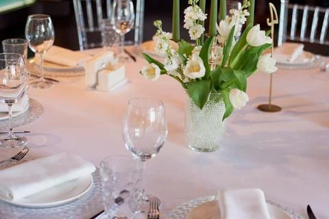 Classic table setting. White tablecloth. Vase with hydrogel and white flowers Stock Photos
